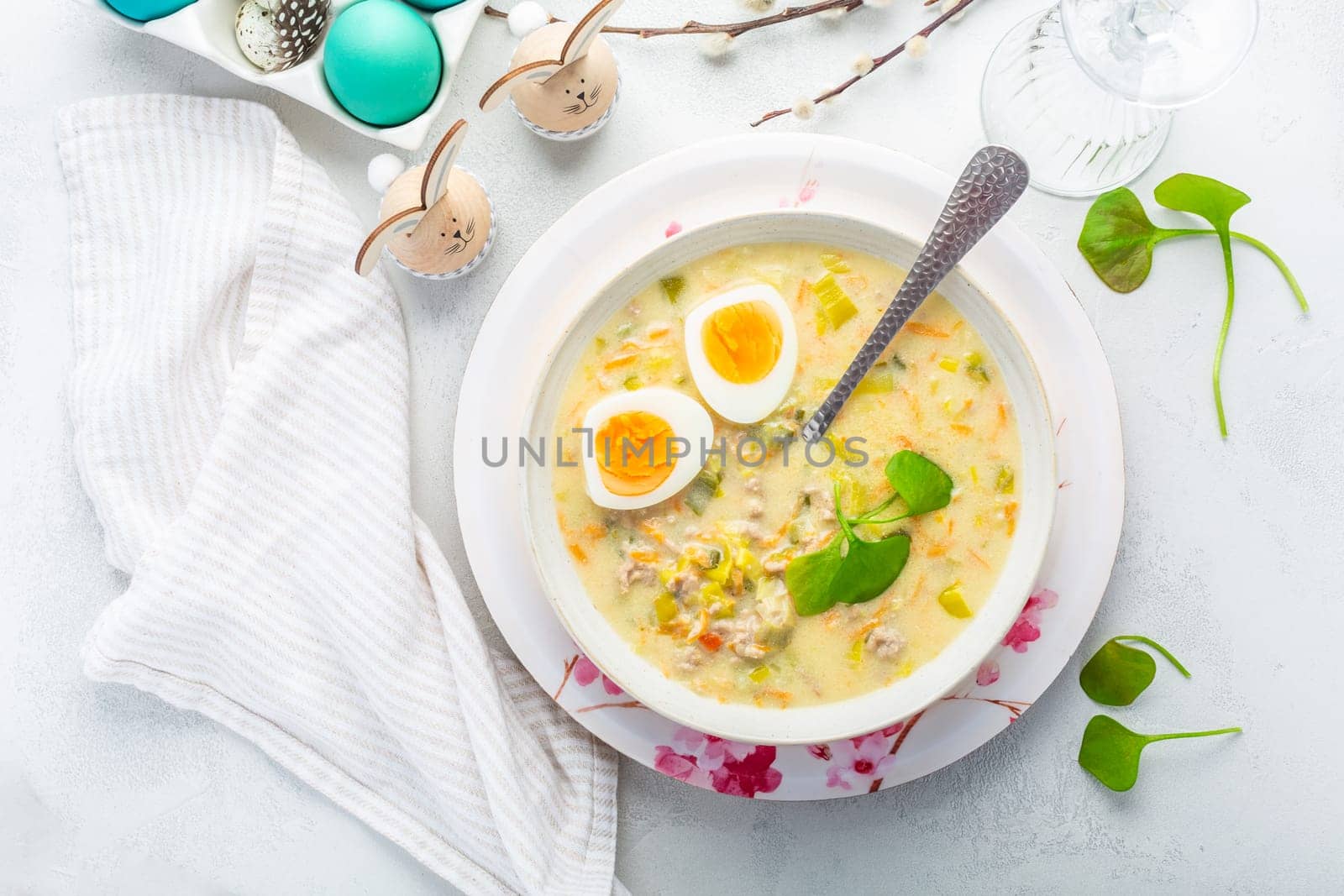 Homemade polish Easter soup with addition of sausage, hard boiled egg and vegetables in a bowl