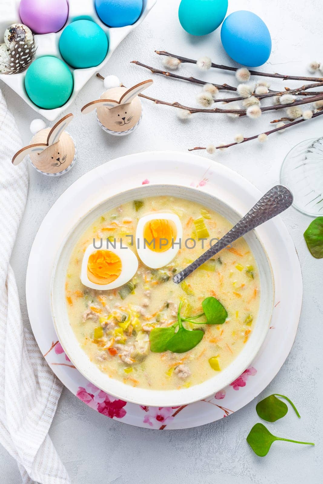 Homemade polish Easter soup with addition of sausage, hard boiled egg and vegetables in a bowl