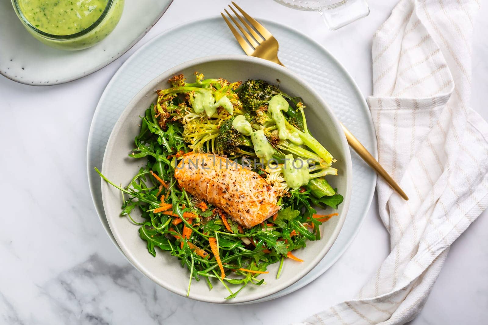 Grilled salmon fillet with parmesan broccoli and fresh vegetable salad, avocado dressing. Mediterranean diet.