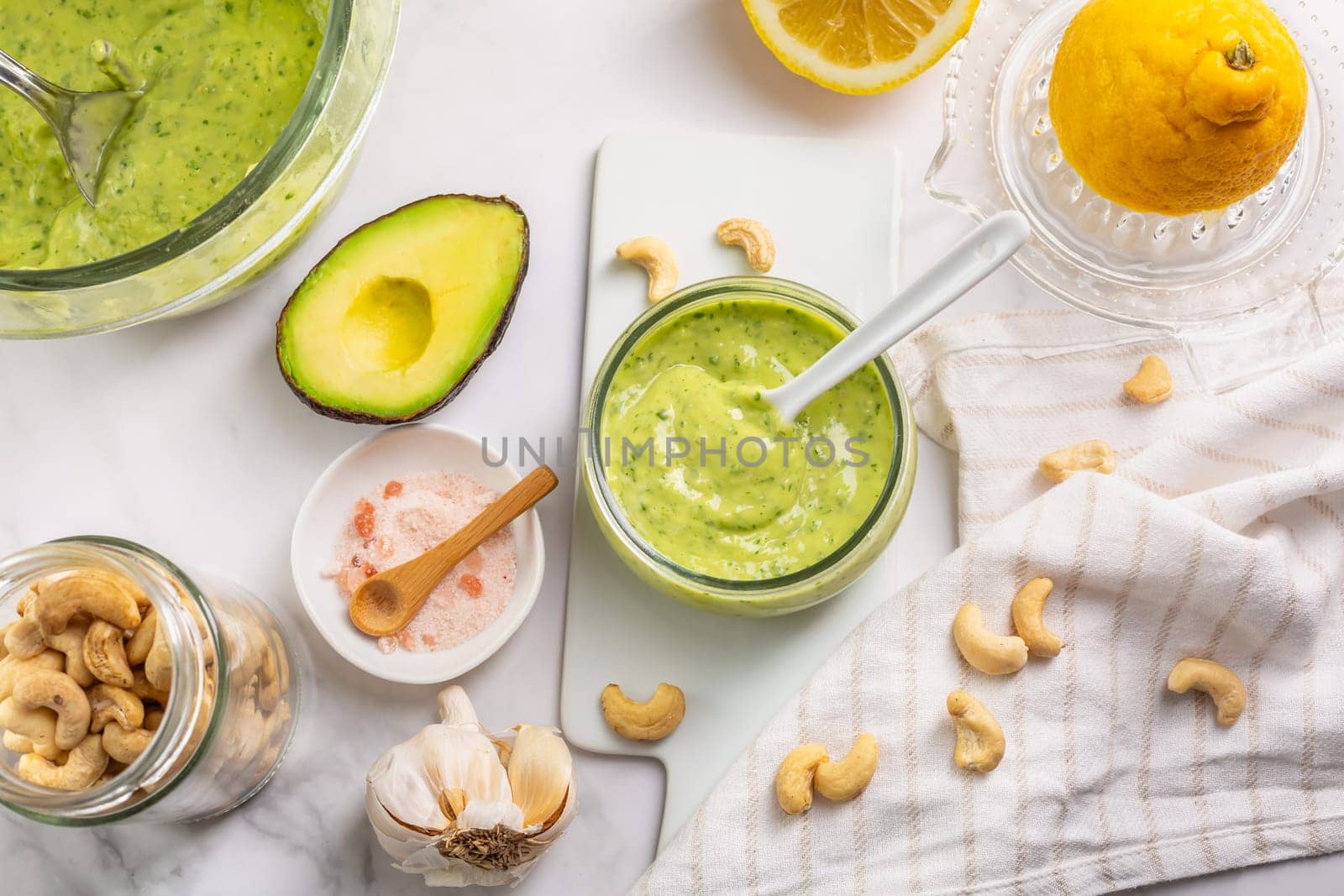 Homemade avocado yogurt dressing with ingredients on kitchen table