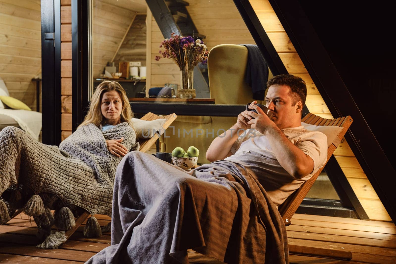 In the evening, a married couple is sitting on the terrace and talking to each other