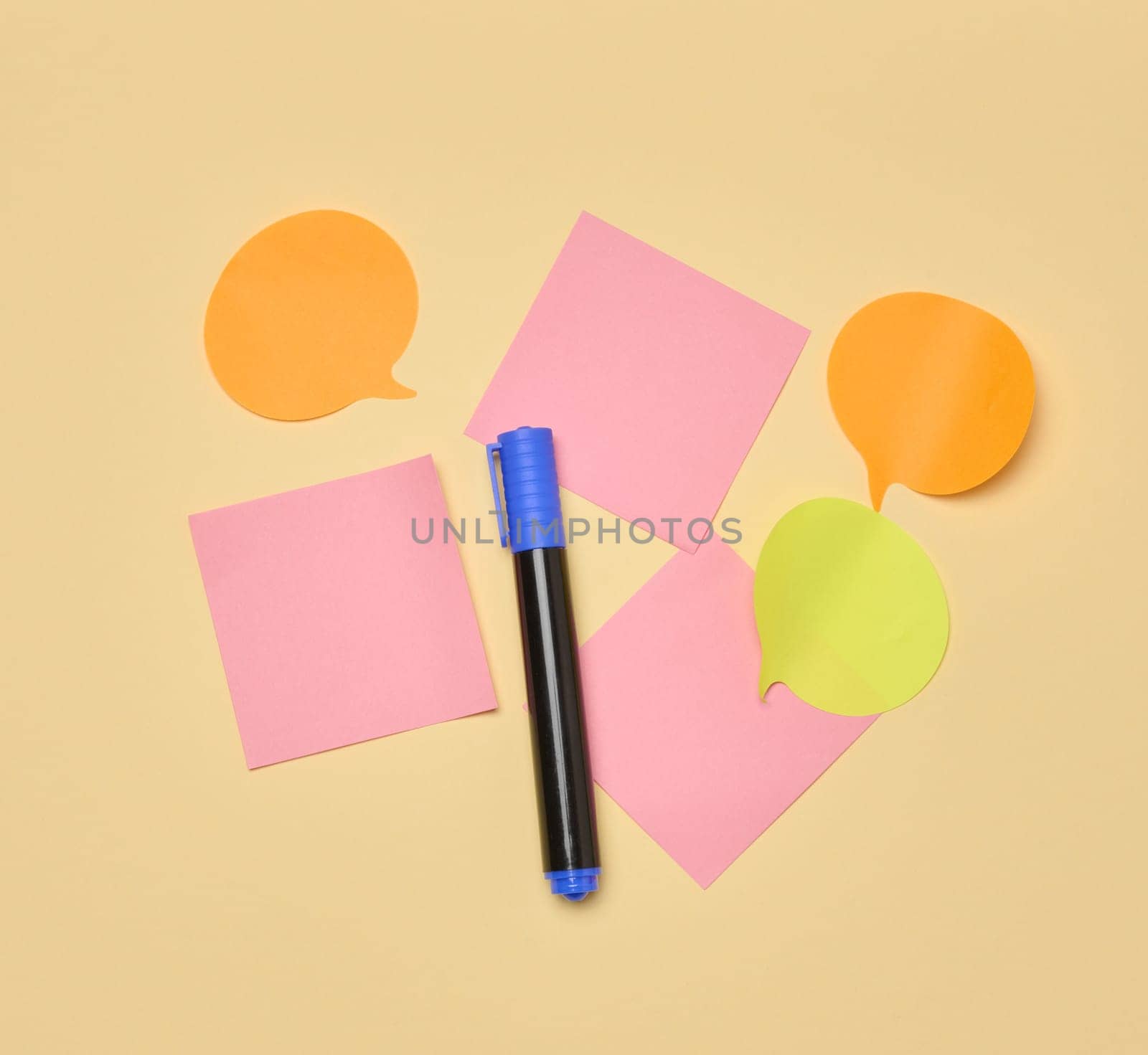 Various paper stickers and felt-tip pens on a yellow background, top view