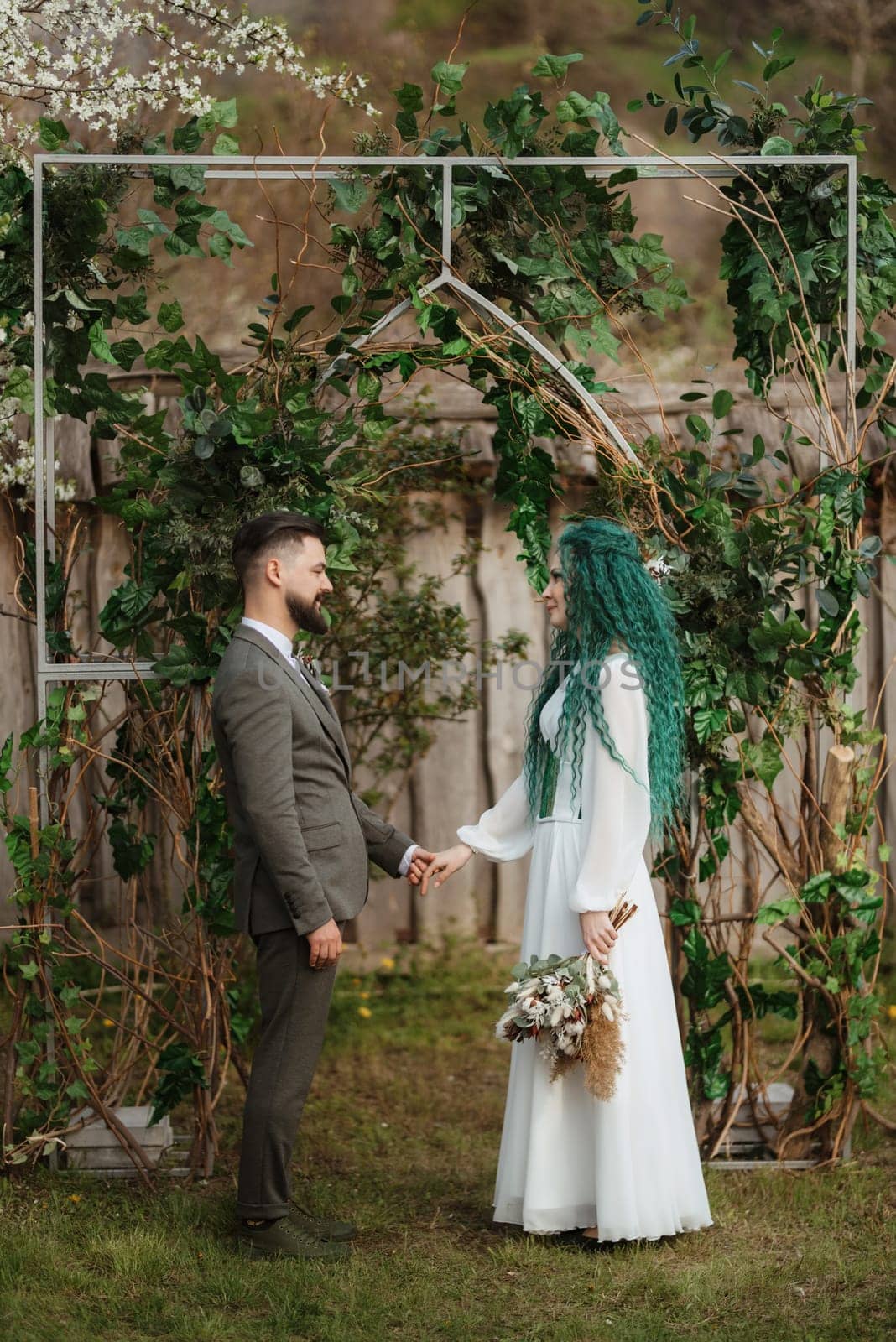 wedding ceremony of the newlyweds in a country cottage on a green hill