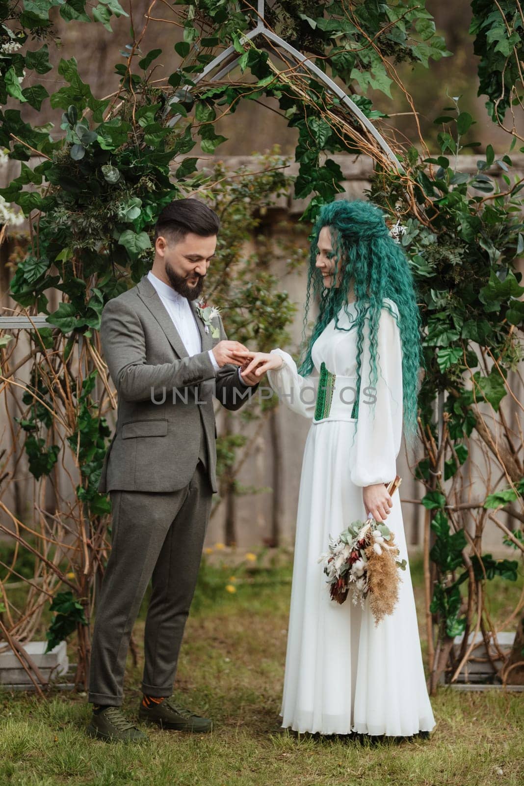 wedding ceremony of the newlyweds in a country cottage on a green hill