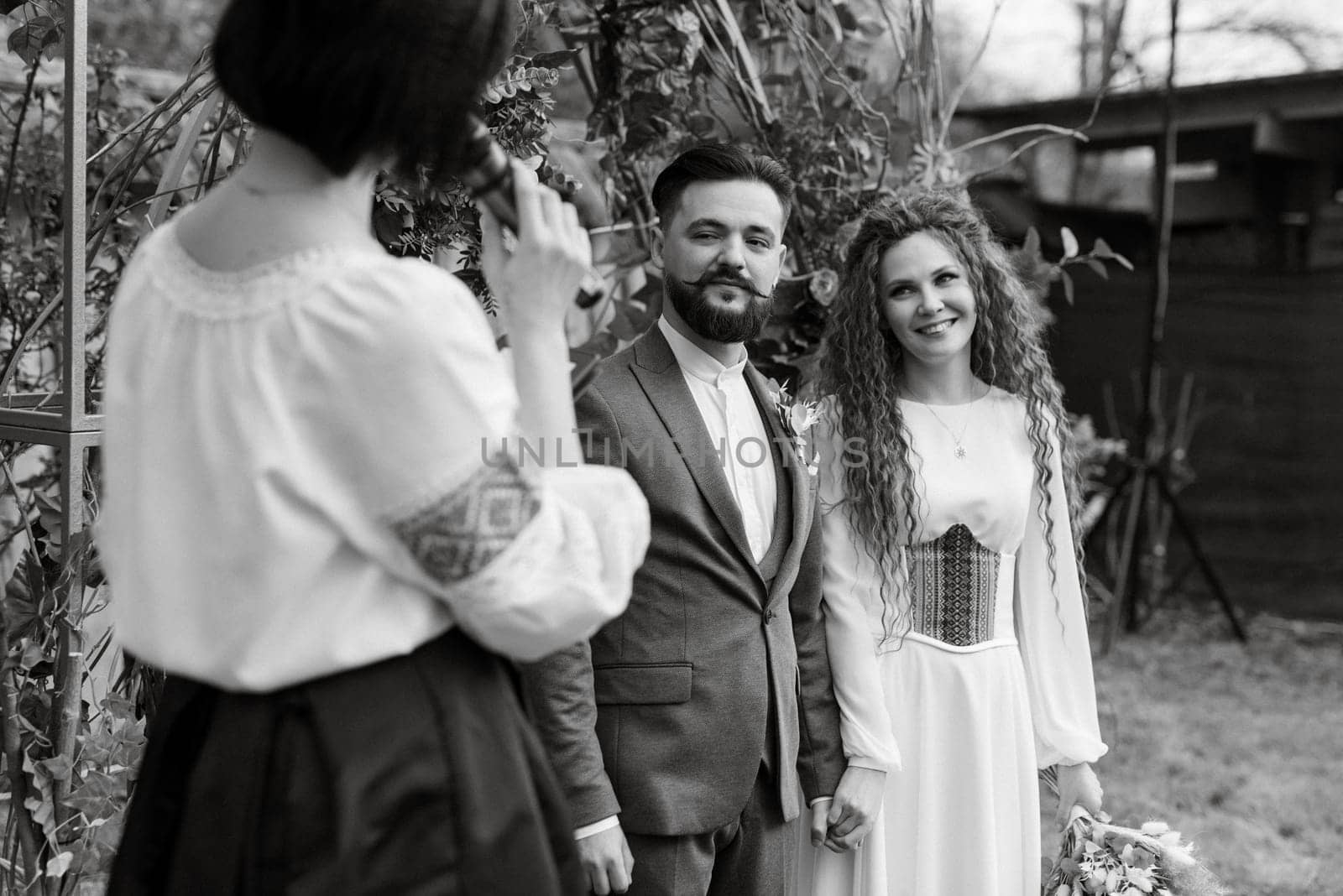 wedding ceremony of the newlyweds in a country cottage on a green hill