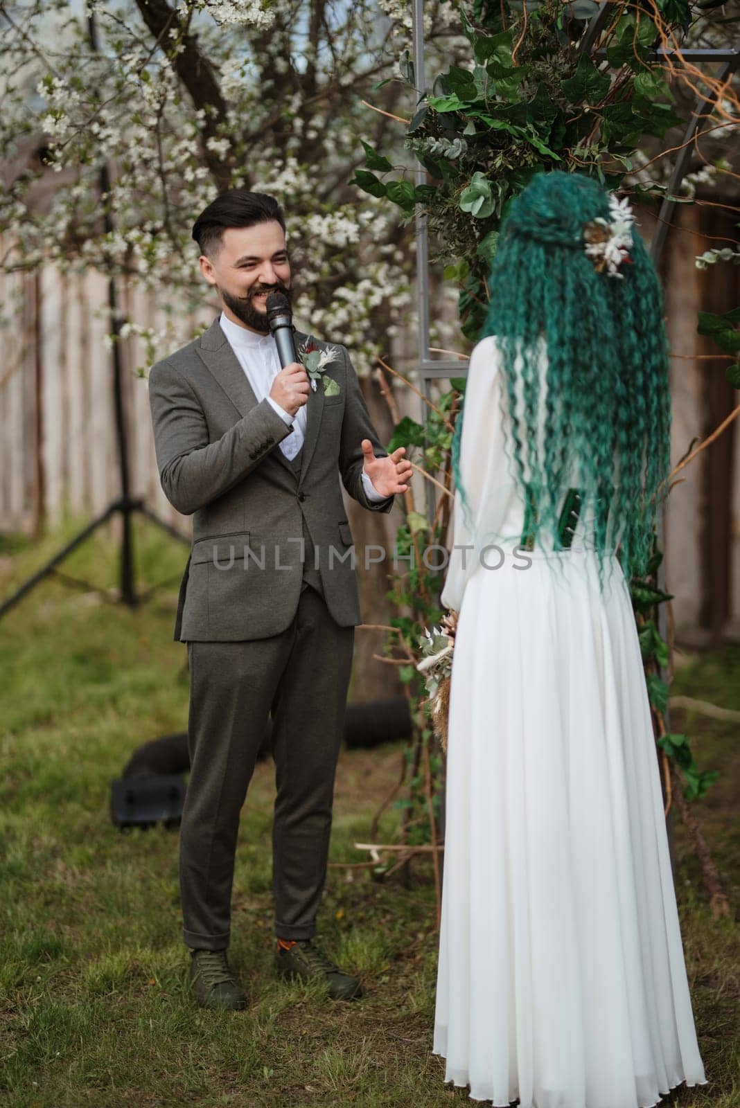 wedding ceremony of the newlyweds in a country cottage on a green hill