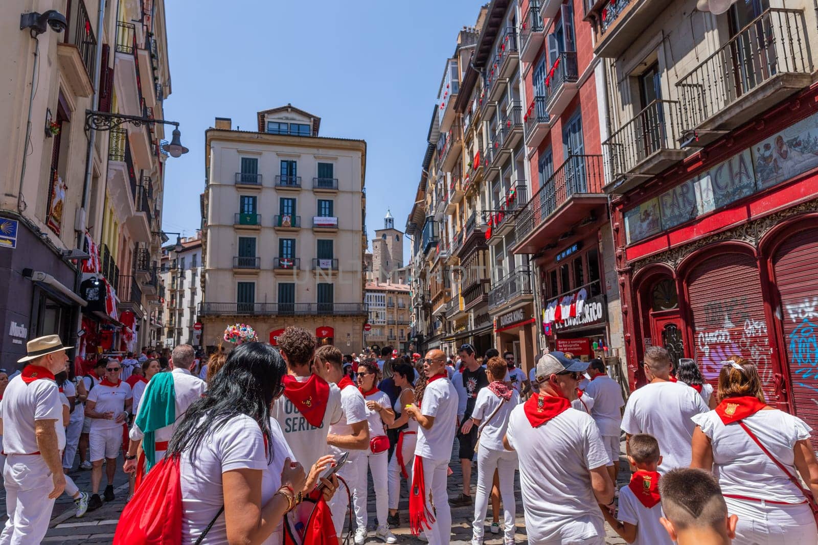 Pamplona, Spain: 09 July 2023: People celebrate San Fermin festival in traditional white abd red clothing with red necktie, Pamplona, Navarra, Spain.