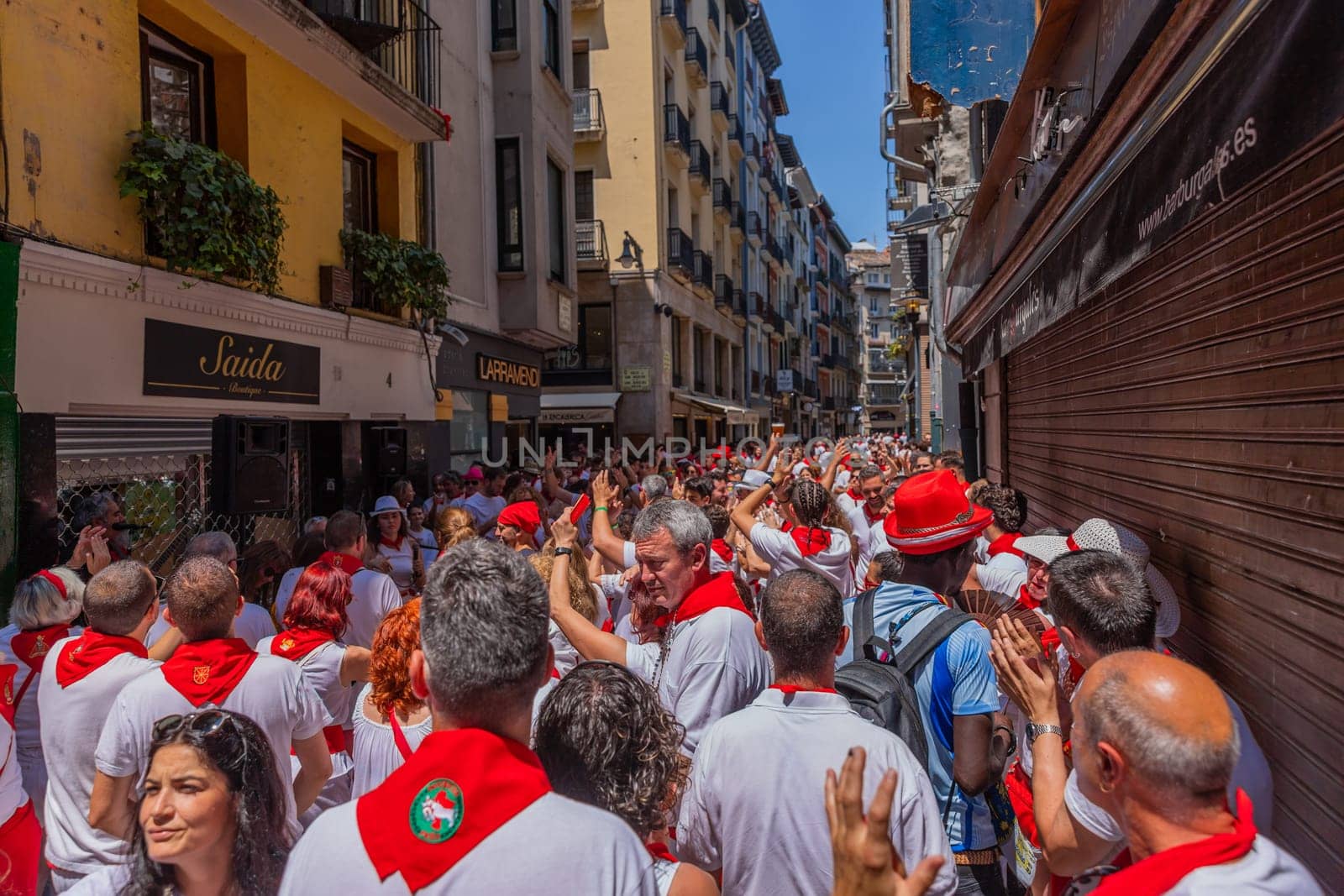 Pamplona, Spain: 09 July 2023: People celebrate San Fermin festival in traditional white abd red clothing with red necktie, Pamplona, Navarra, Spain.