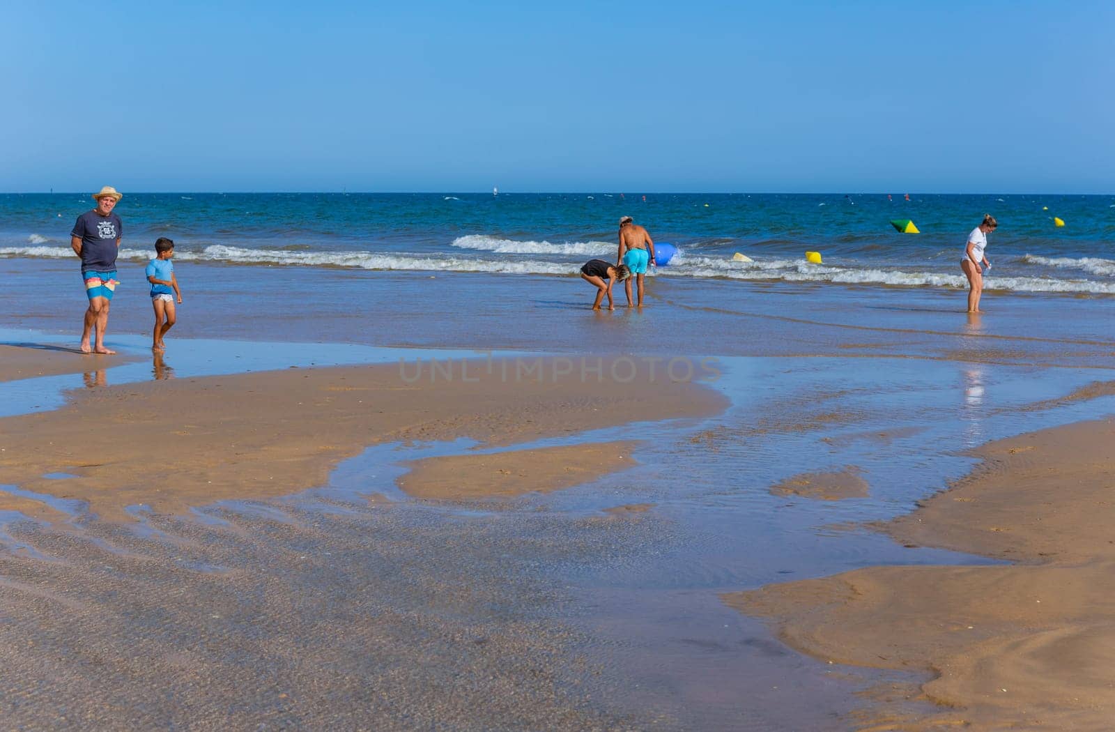 Tavira, Portugal - August 15, 2023: People at the famous beach of Tavira island in Tavira. This beach is a part of famous tourist region of Algarve.