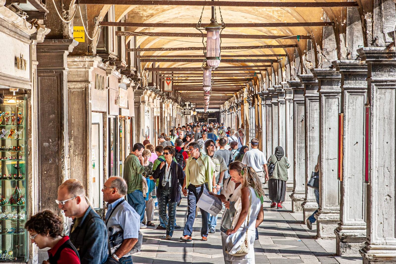 Venice, Italy - September 23, 2005: people enjoy walking along the collonades at San Marco square in Venice, Italy.