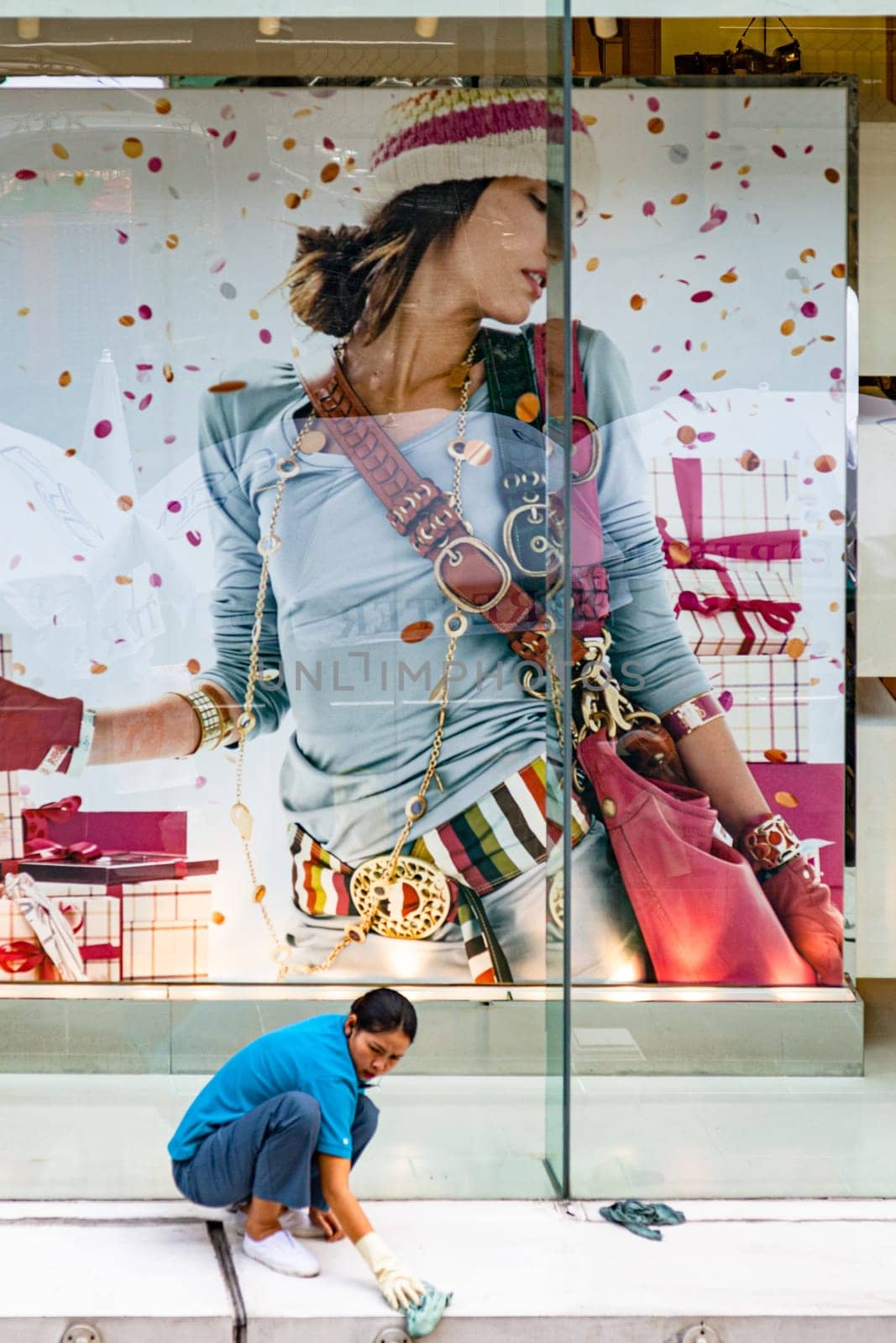 Bangkok, Thailand - December 27, 2007: women cleans the shopping window and facade of an expensive shopping mall downtown Bangkok.