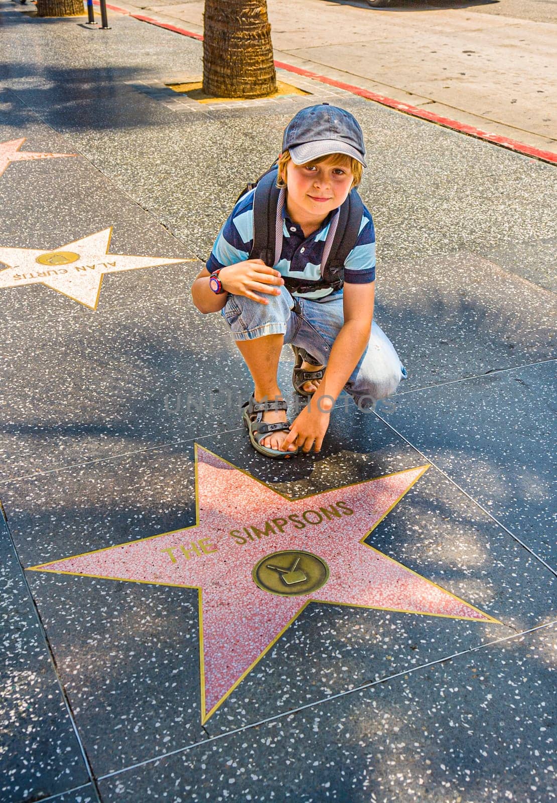 Los Angeles, USA - July 5, 2008: boy at the  Walk of Fame poses at the star for The simpsons.