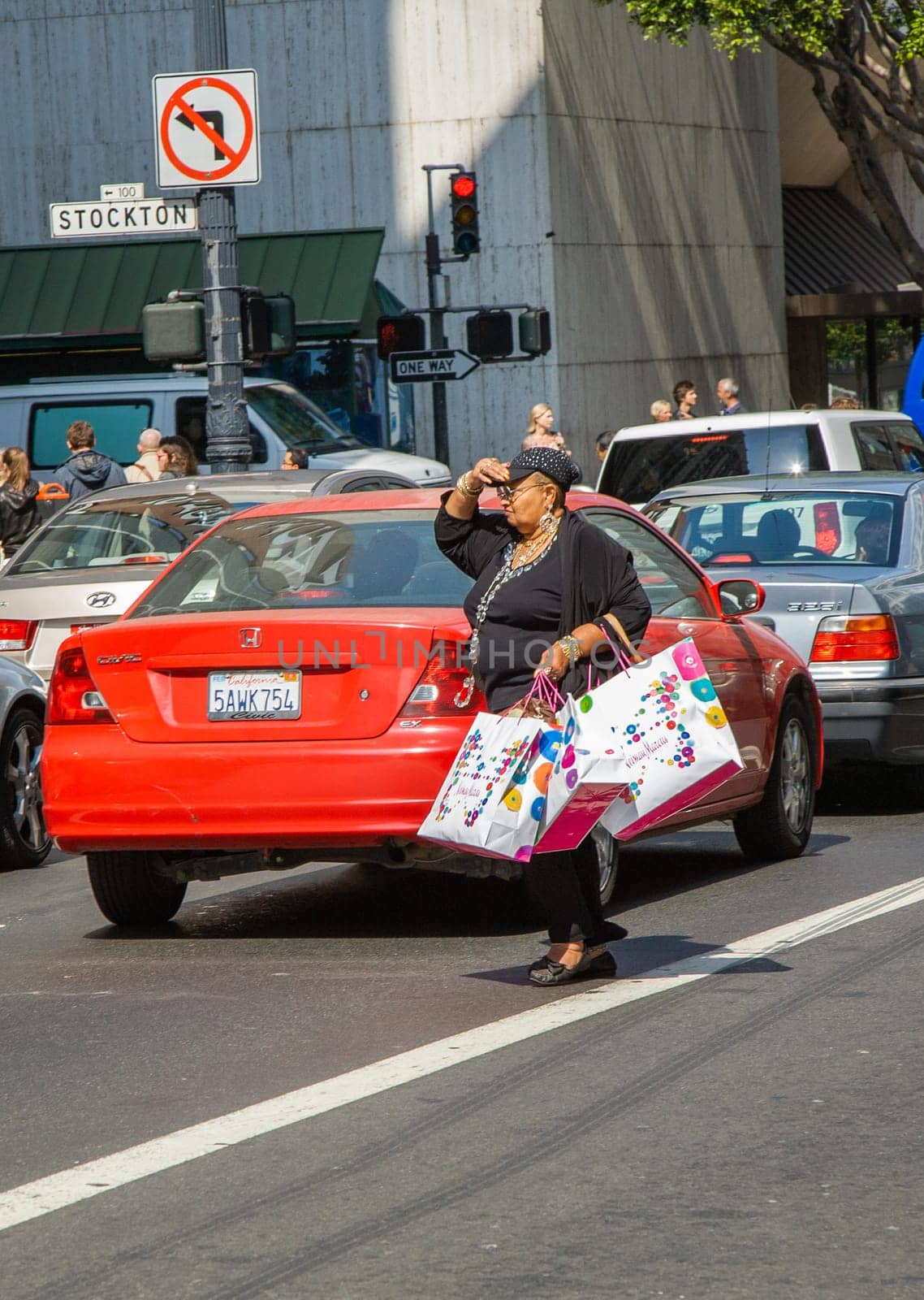 San Francisco, USA - July 24, 2008: woman with fully filled shopping bag crosses a street downtown San Francisco after shopping.