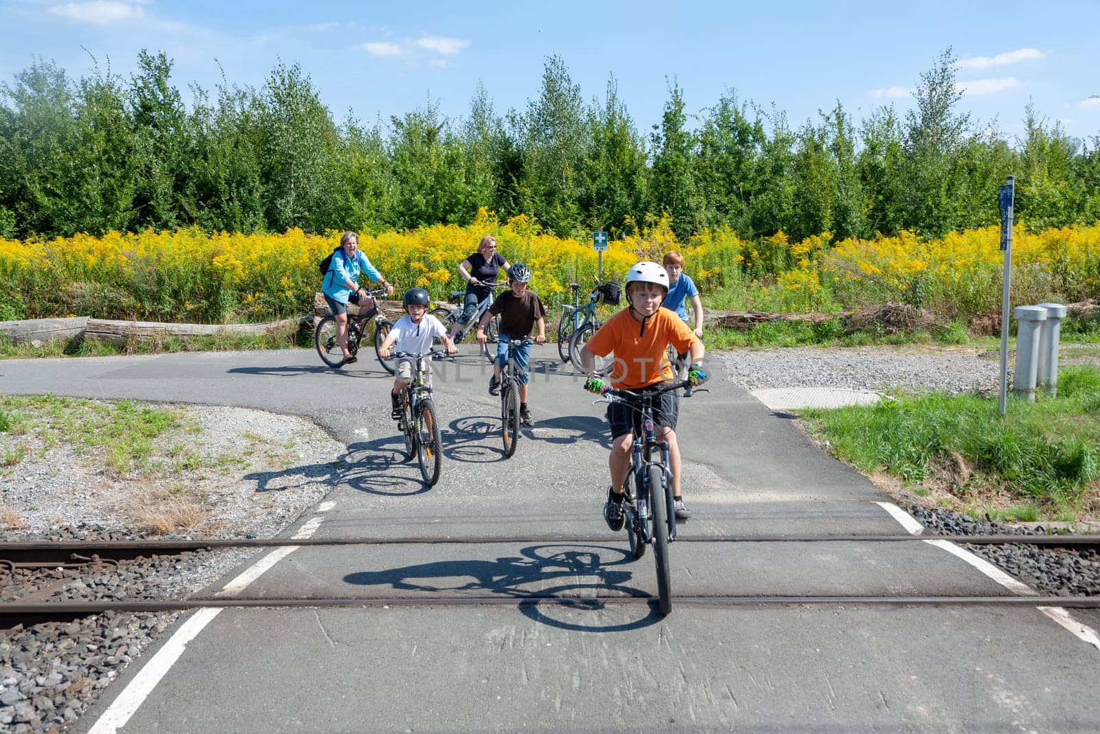 Frankfurt, Germany - August 23, 2009: family at a railway crossing enjoys the bicycle ride in the nature on a sunny summer day.