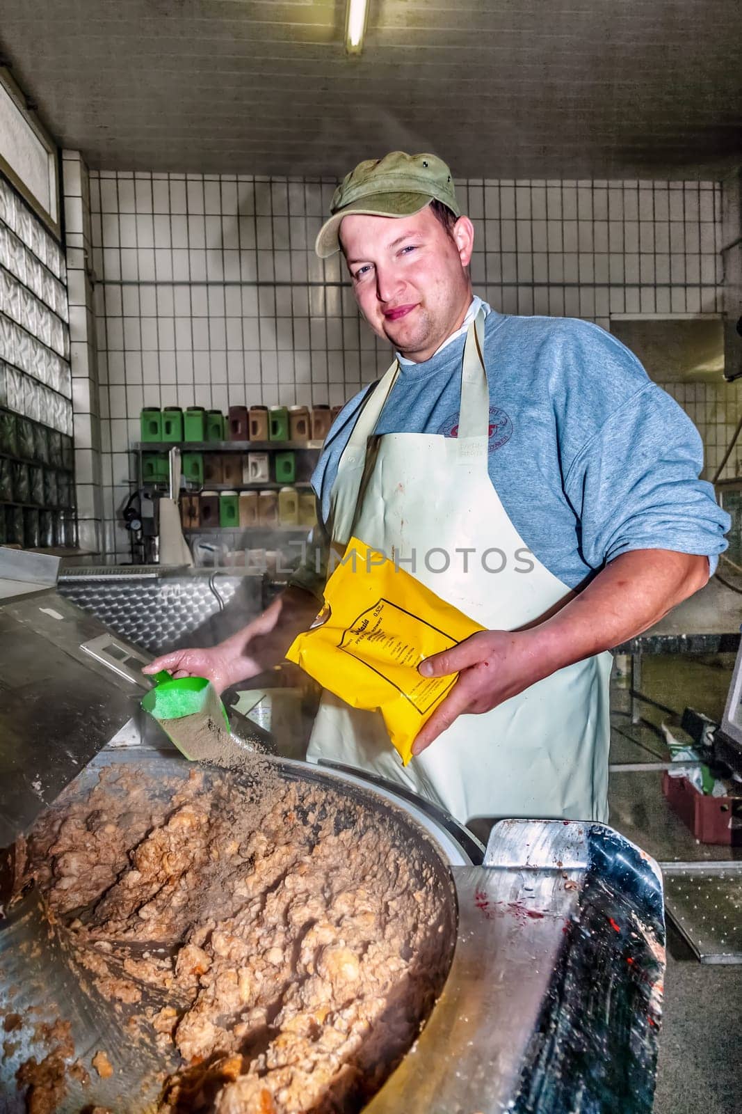 Hoesbach, Germany - October 15, 2009: butcher prepares fresh sausage in Hoesbach, Germany. The average person in Germany will consume up to 61 kg  of meat in a year.
