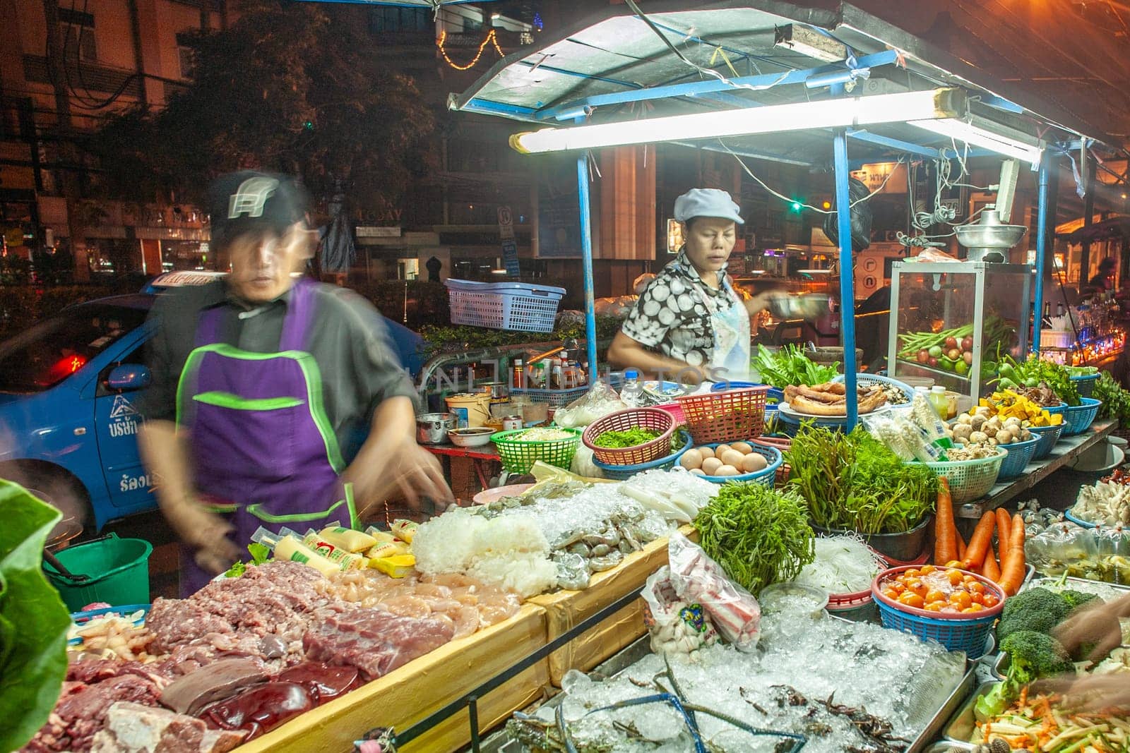 Bangkok, Thailand - DEcember 21, 2009: food hawker at the night market along the street offer fresh warm food from the movable small kitchen