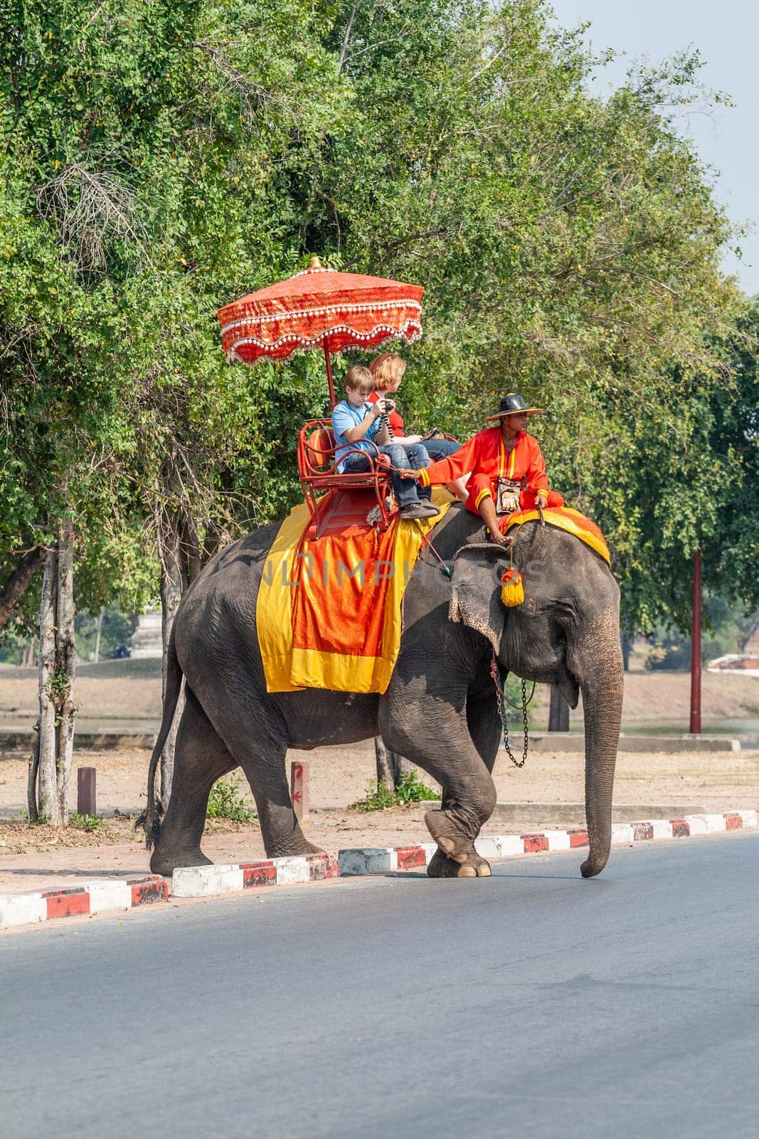 Ayutthaya, Thailand - December 24, 2009: tourists enjoy the elephant ride guided by a mahout in Ayutthaya.