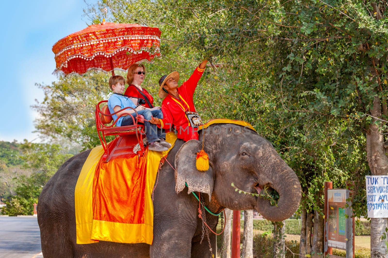 Ayutthaya, Thailand - December 24, 2009:  tourists ride on an elephant in the Historical Park in Ajutthaya, Thailand. It is called a must in Ayutthaya and costs about 1000 BATH for 30 min.