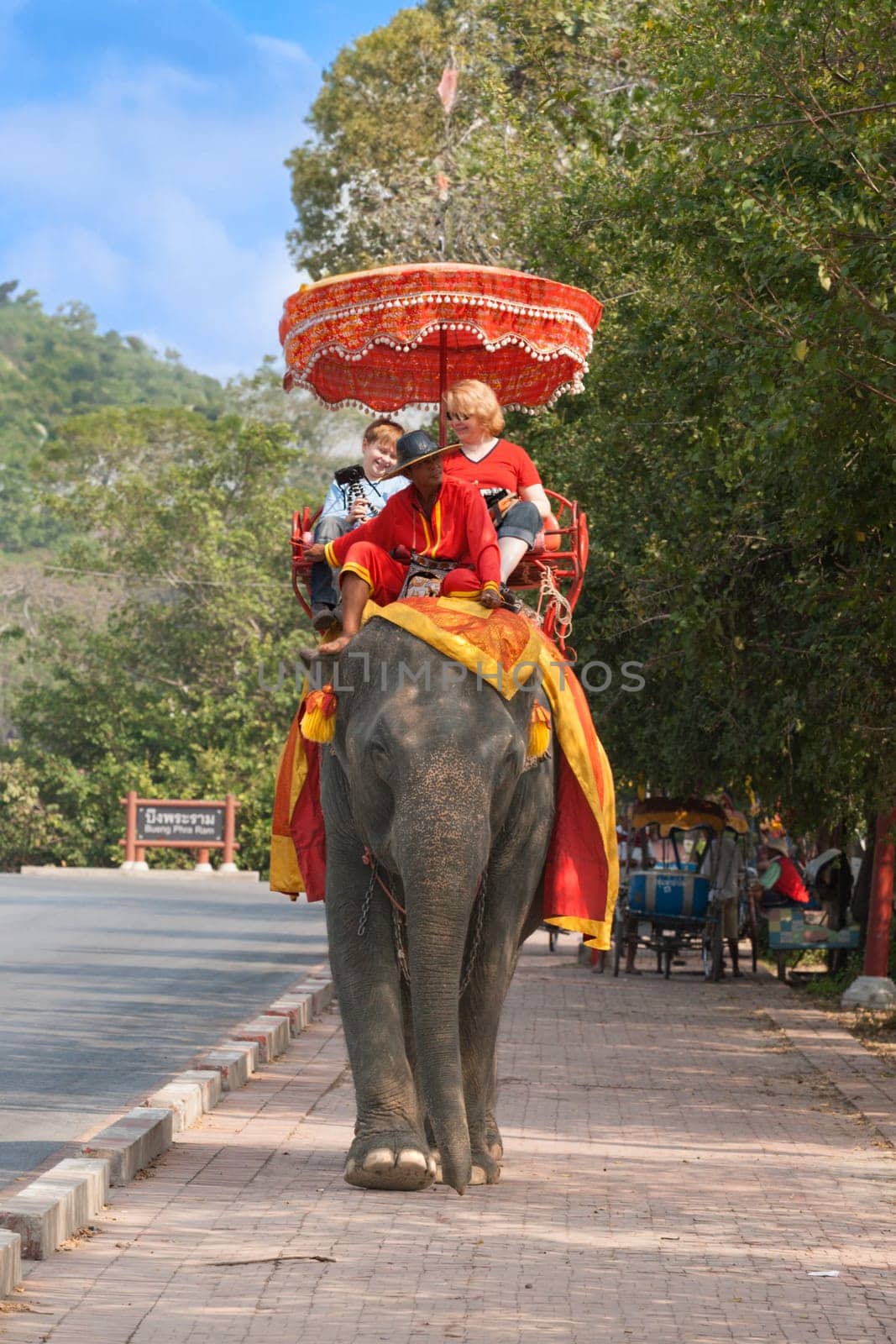 Ayutthaya, Thailand - December 24, 2009:  tourists ride on an elephant in the Historical Park in Ajutthaya, Thailand. It is called a must in Ayutthaya and costs about 1000 BATH for 30 min.