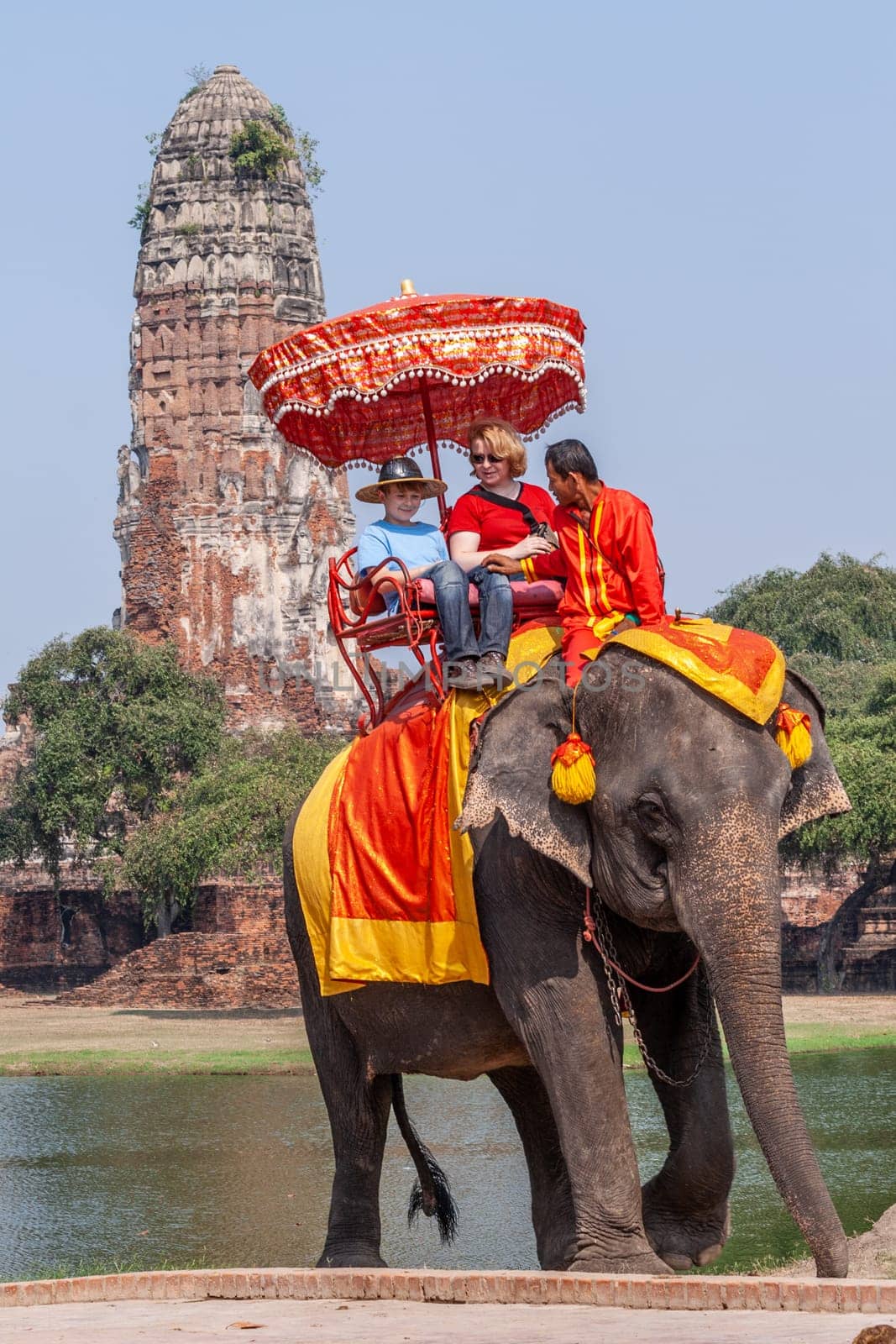Ayutthaya, Thailand - December 24, 2009: tourists enjoy the elephant ride guided by a mahout in Ayutthaya.