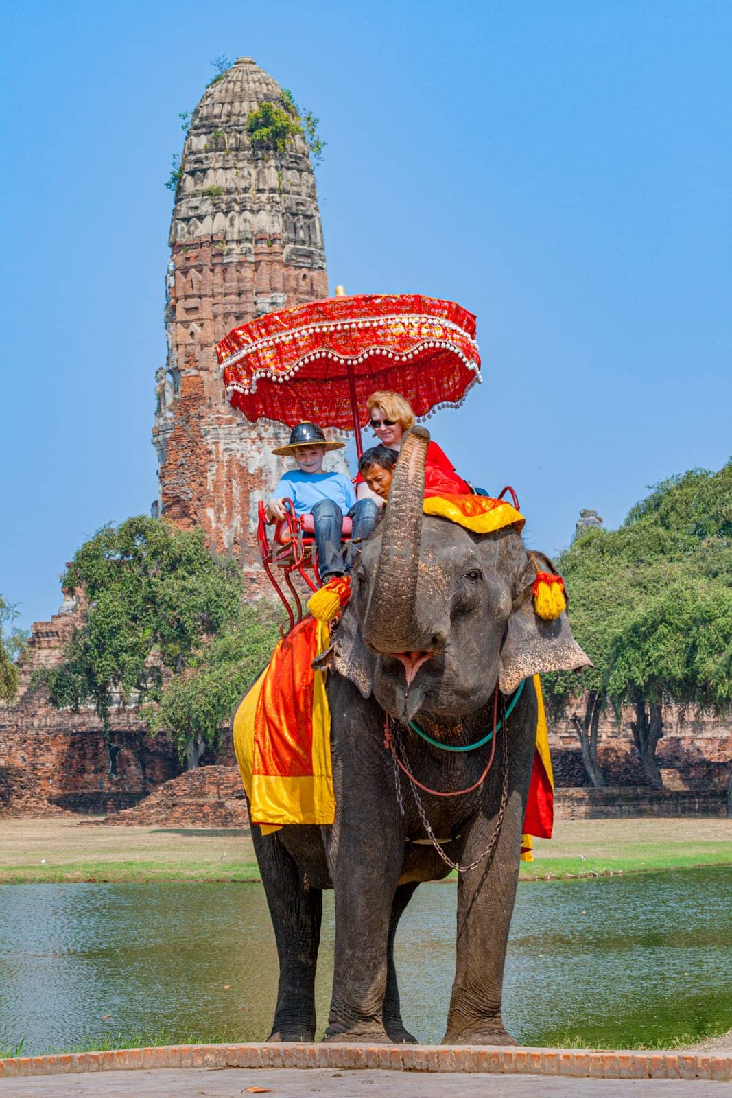 Ayutthaya, Thailand - December 24, 2009:  tourists ride on an elephant in the Historical Park in Ajutthaya, Thailand. It is called a must in Ayutthaya and costs about 1000 BATH for 30 min.