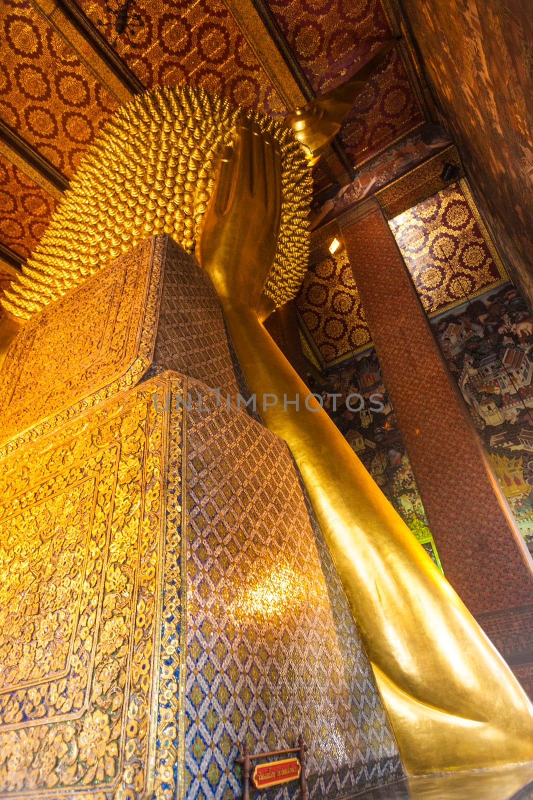 Bangkok, Thailand - January 4, 2010: Detail of the Reclining Buddha statue in temple Wat Pho in Bangkok, Thailand. Statue is 15 m high and 43 m long with his right arm supporting head.