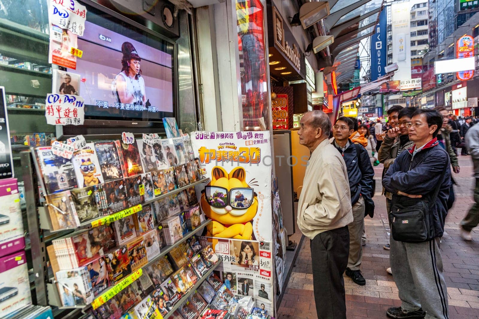 Hongkong, China - January 7, 2010: shopping street in late afternoon with illuminated shops and people hurry around in downtown Hongkong, Kowloon.