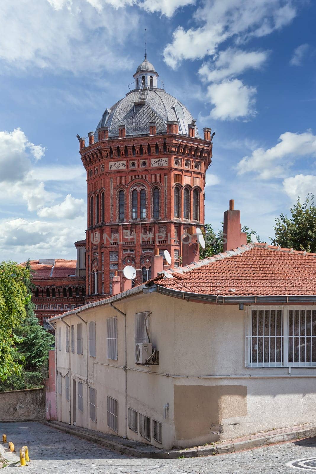 Cobblestone alley in old Balat district, with Phanar Greek Orthodox College, or Ozel Fener Rum Lisesi, Istanbul, Turkey