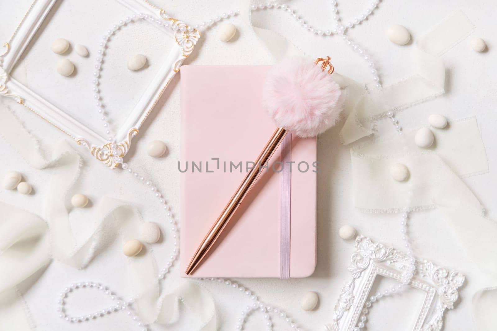Pink school notebook, decorative gemstone pen and romantic decor on white top view. Textbook mockup. Dairy cover with place fot text. Valentines, educational and girly concept