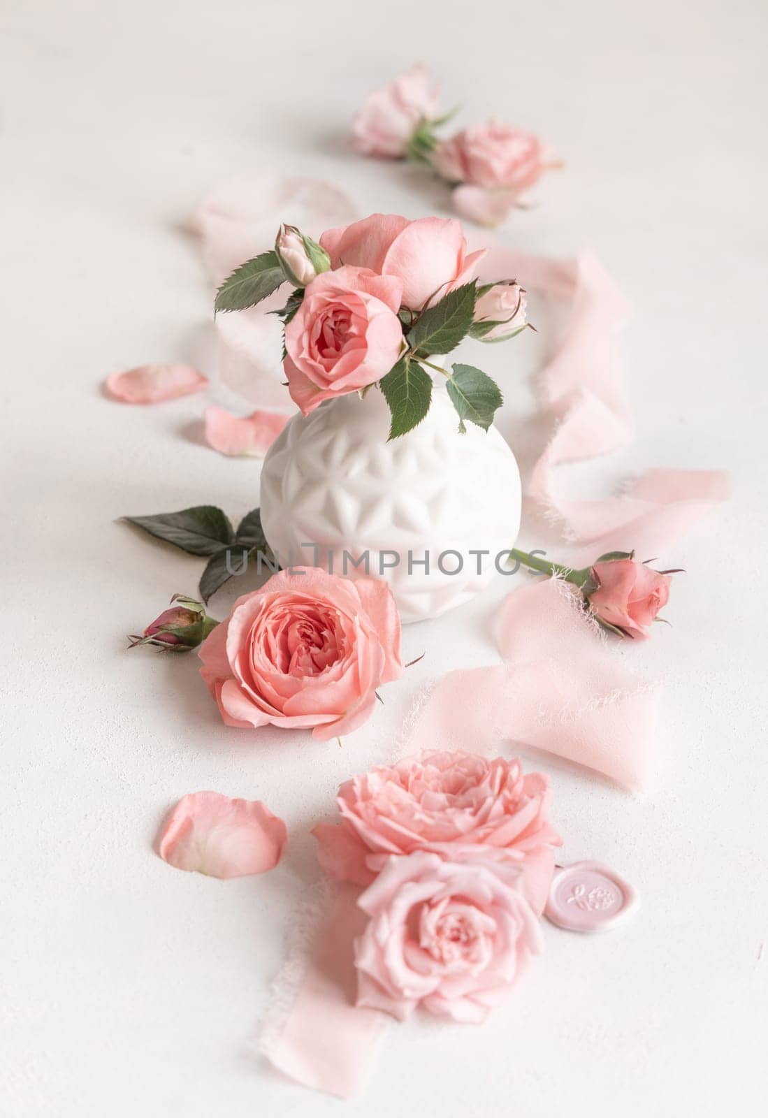 Light pink roses in a vase, petals and buds on white table close up, romantic and wedding concept, valentines day scene, spring atmosphere background