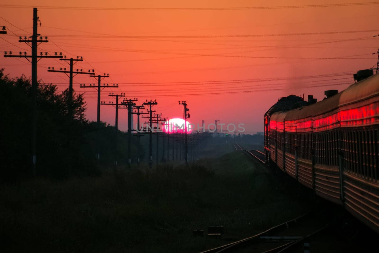 Passenger train rides against the sunset, Railway at sunset