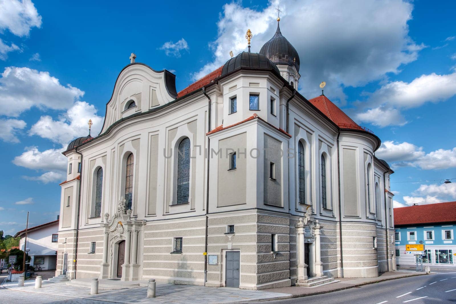 Nesselwang, Germany - July 06, 2023: Wide angle corner view of the Saint Andreas Church in Nesselwang from the south-west against a blue sky with white clouds.