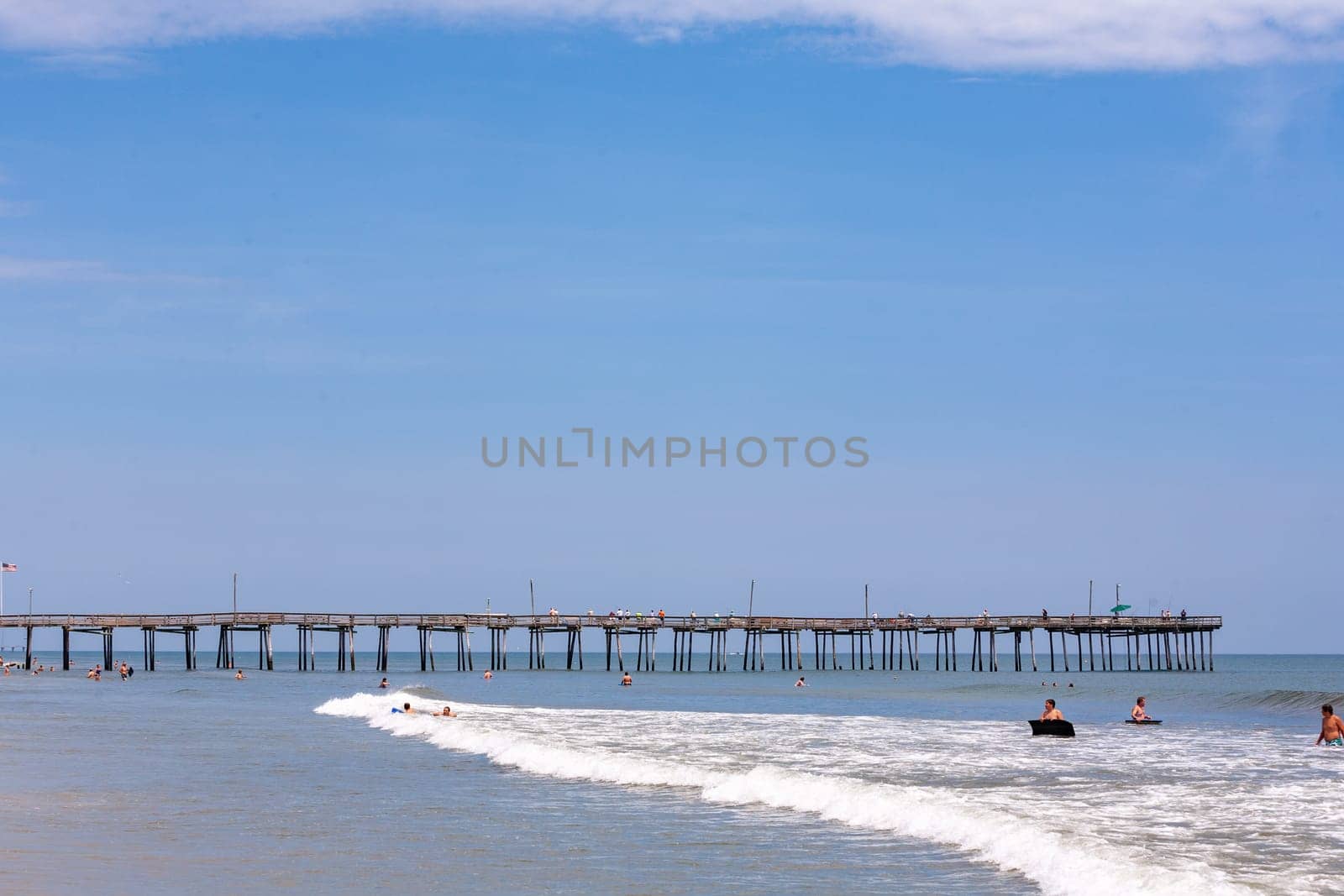 Nags Head, USA - July 18, 2010: people enjoy the old wooden pier beach at Nags Head, South Carolina.