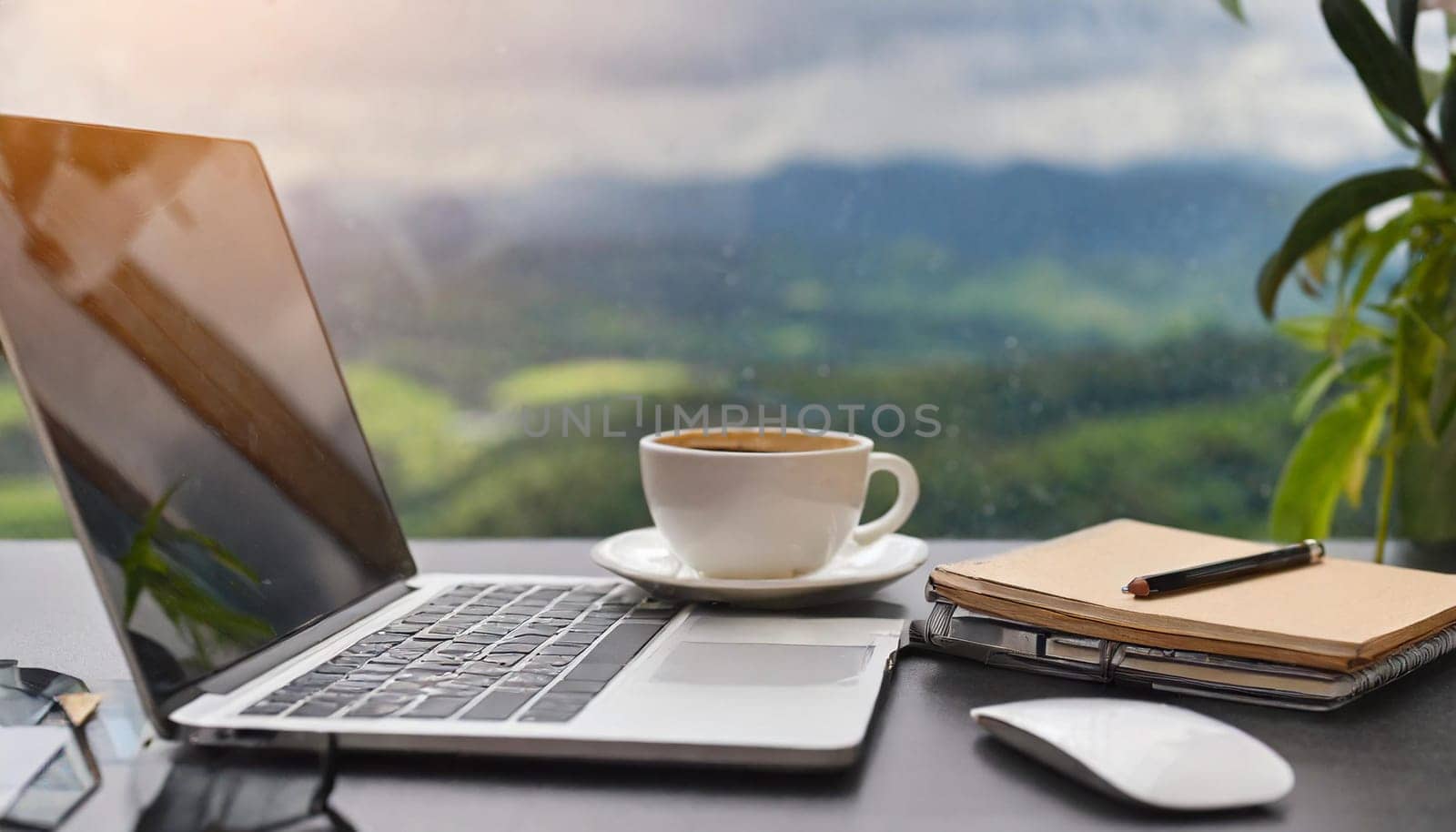 Modern workplace with laptop computer, coffee cup and office supplies