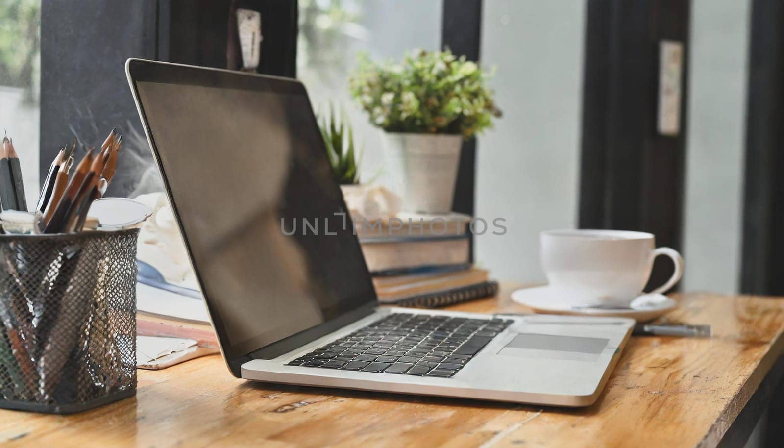 Modern workplace with laptop computer, coffee cup and office supplies