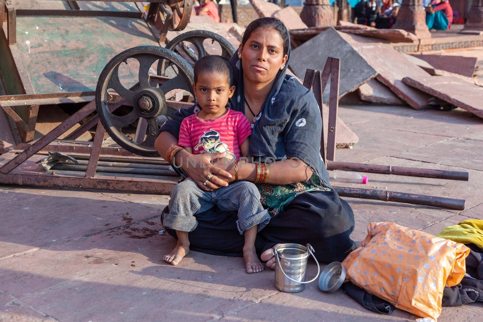 Delhi, India - November 10, 2011: mother with child rests on the courtyard of Jama Masjid Mosque in Delhi. Jama Masjid is the principal mosque of Old Delhi in India.