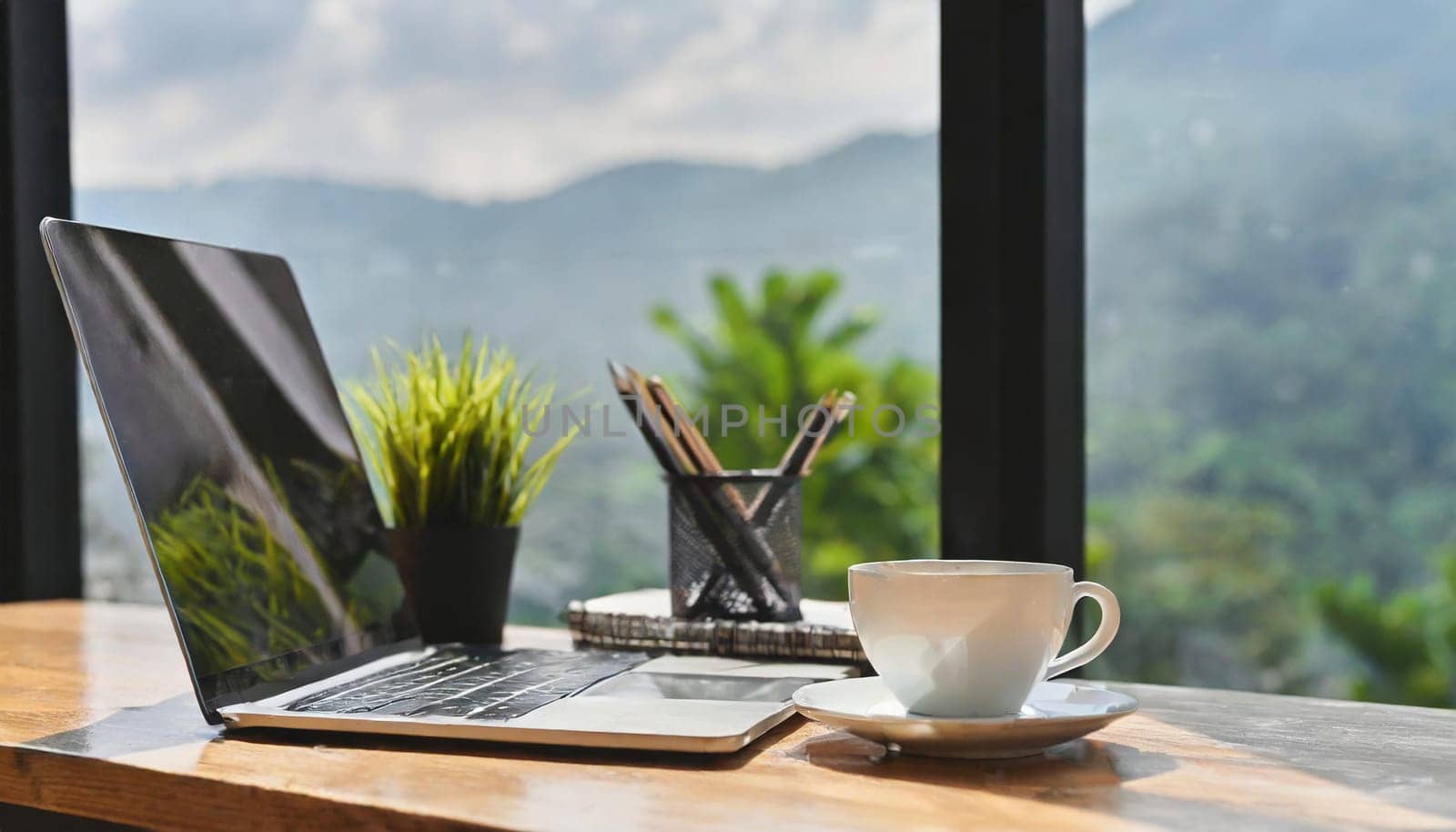 Modern workplace with laptop computer, coffee cup and office supplies