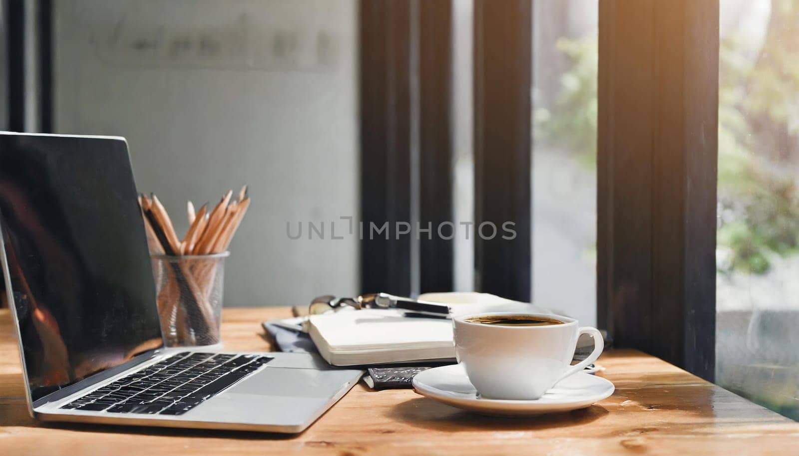 Modern workplace with laptop computer, coffee cup and office supplies