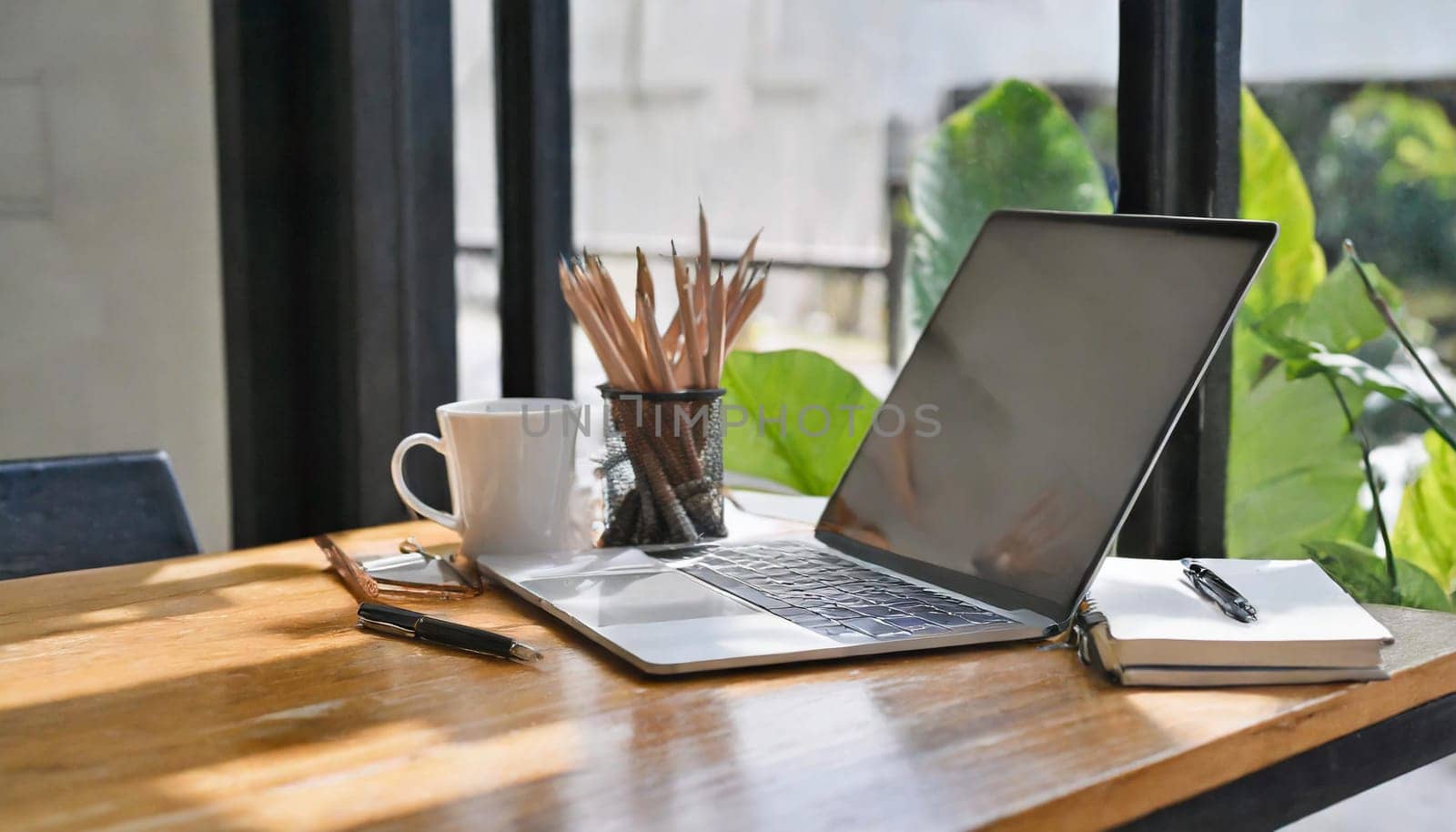 Modern workplace with laptop computer, coffee cup and office supplies