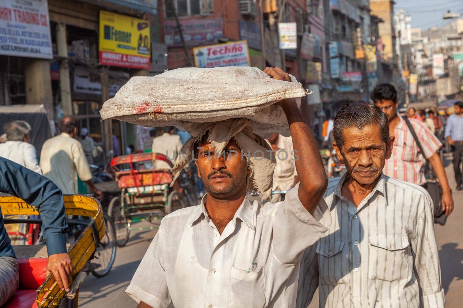 New Delhi, India - November 17, 2011: streetlife at oldest market Chandni Chowk in old Delhi. People carrying goods on the head at Meena Bazaar in Chandni Chowk.