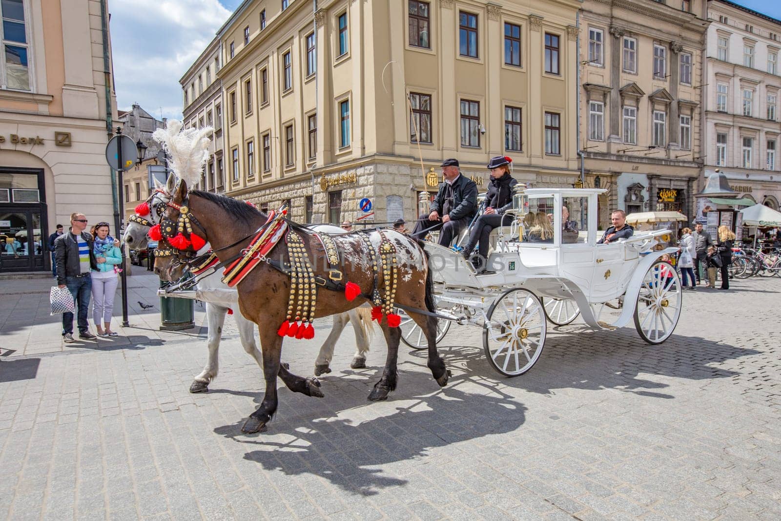 Krakow, Poland - May 4, 2014: Horse-drawn carriage at the Market Square, standardized the color, total length of no more than 7.0 m, can be harnessed to a max of two horses in Krakow, Poland.