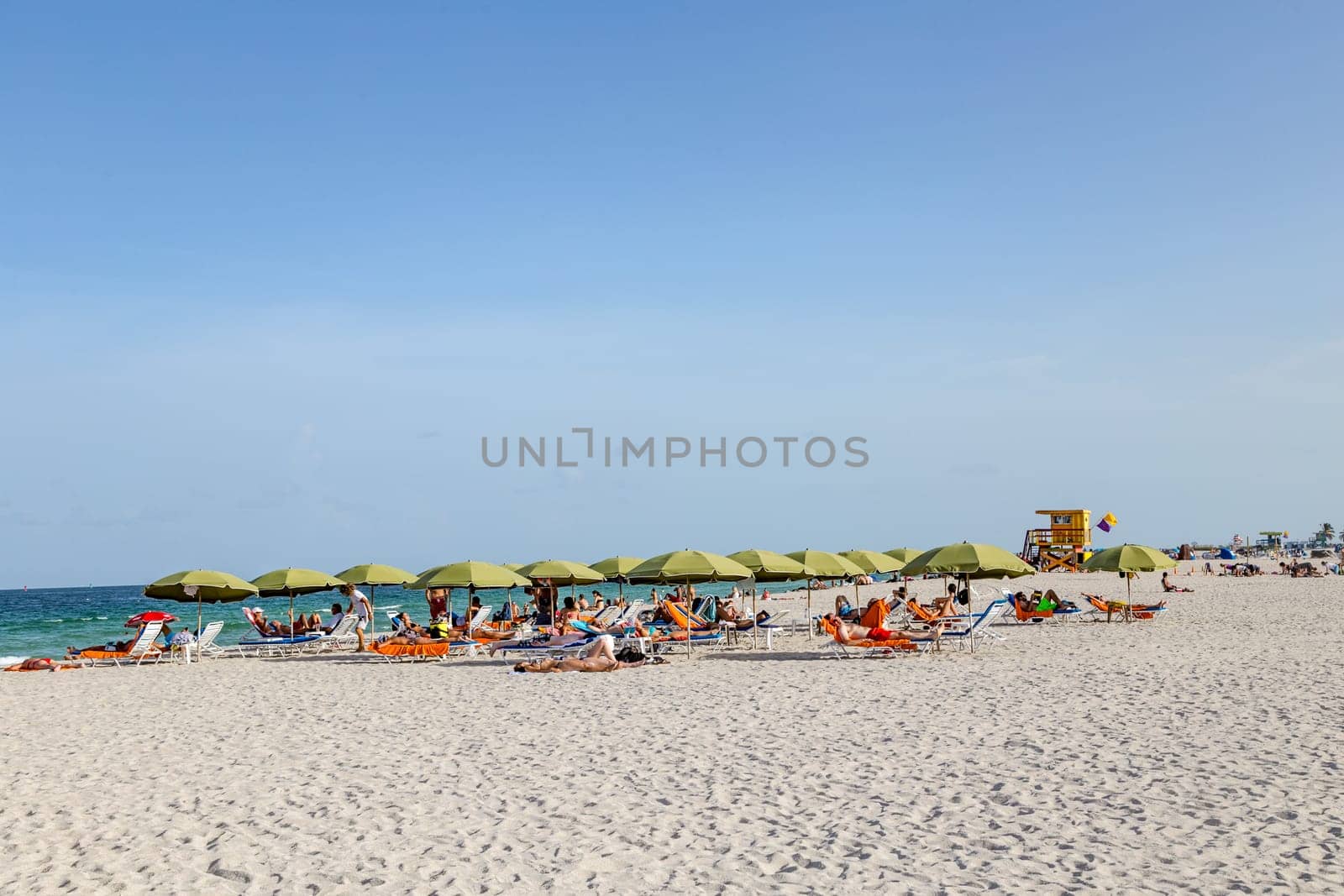 Miami, USA - August 18, 2014: People at the sea side in Miami, USA. Miami Beach is a popular destination among tourists, spiking during the winter time.
