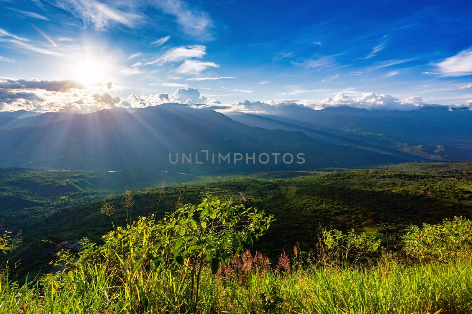 Sunset view from the most known El Camino Real trail in Barichara, Colombia. The trail is surrounded by lush greenery and offers stunning views of the surrounding hills of Andes mountains.
