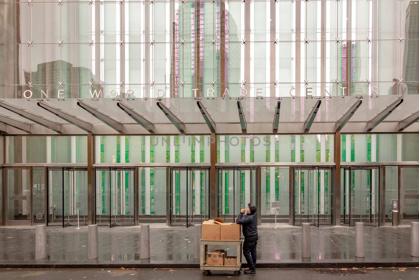New York, USA - November 5, 2018: entrance doors of one world trade center with man delivering a parcel.