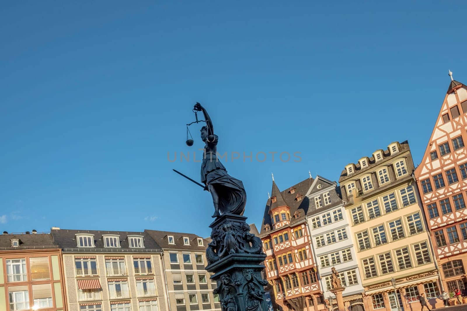 Frankfurt, Germany - January 14, 2019: lady Justice in Frankfurt with view to half timbered houses of the Roemer area in Frankfurt