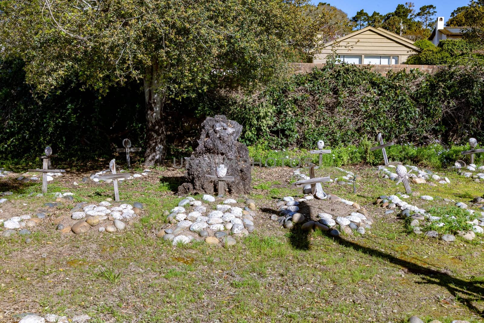 Carmel, USA - March 15, 2019: Grave sites of native Americans  - Indians - at the Carmel Mission are marked with stone circles and wooden crosses with abalone shells.