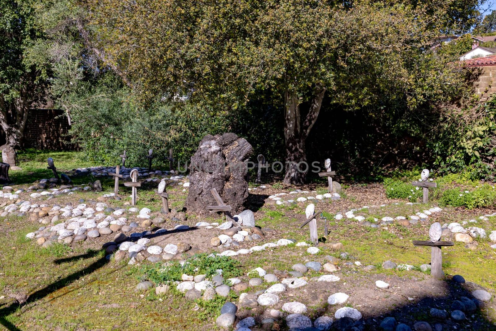 Carmel, USA - March 15, 2019: Grave sites of native Americans  - Indians - at the Carmel Mission are marked with stone circles and wooden crosses with abalone shells.