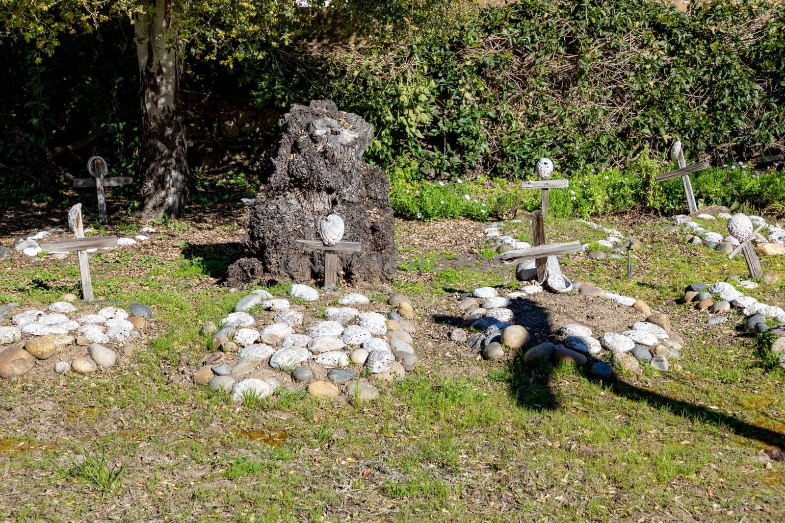 Carmel, USA - March 15, 2019: Grave sites of native Americans  - Indians - at the Carmel Mission are marked with stone circles and wooden crosses with abalone shells.