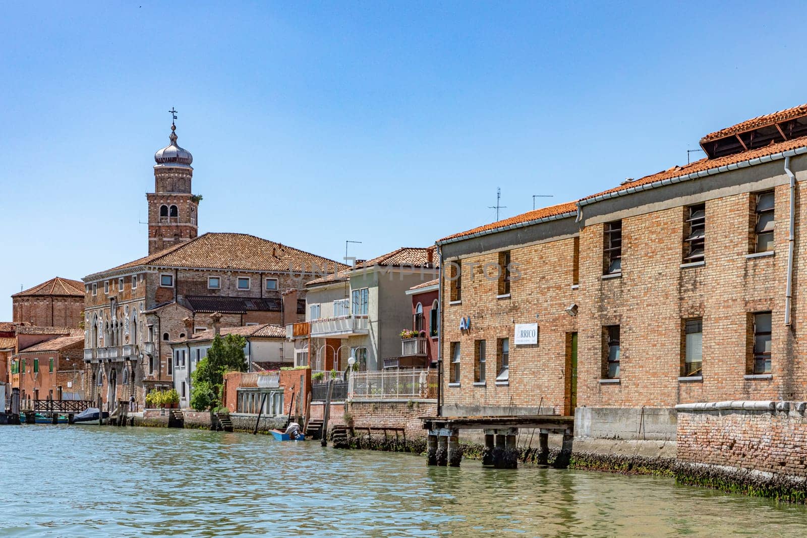 Murano, Italy - July 1, 2021: panoramic view to canal in Burano, the island of venice with historic glass blowing industry.