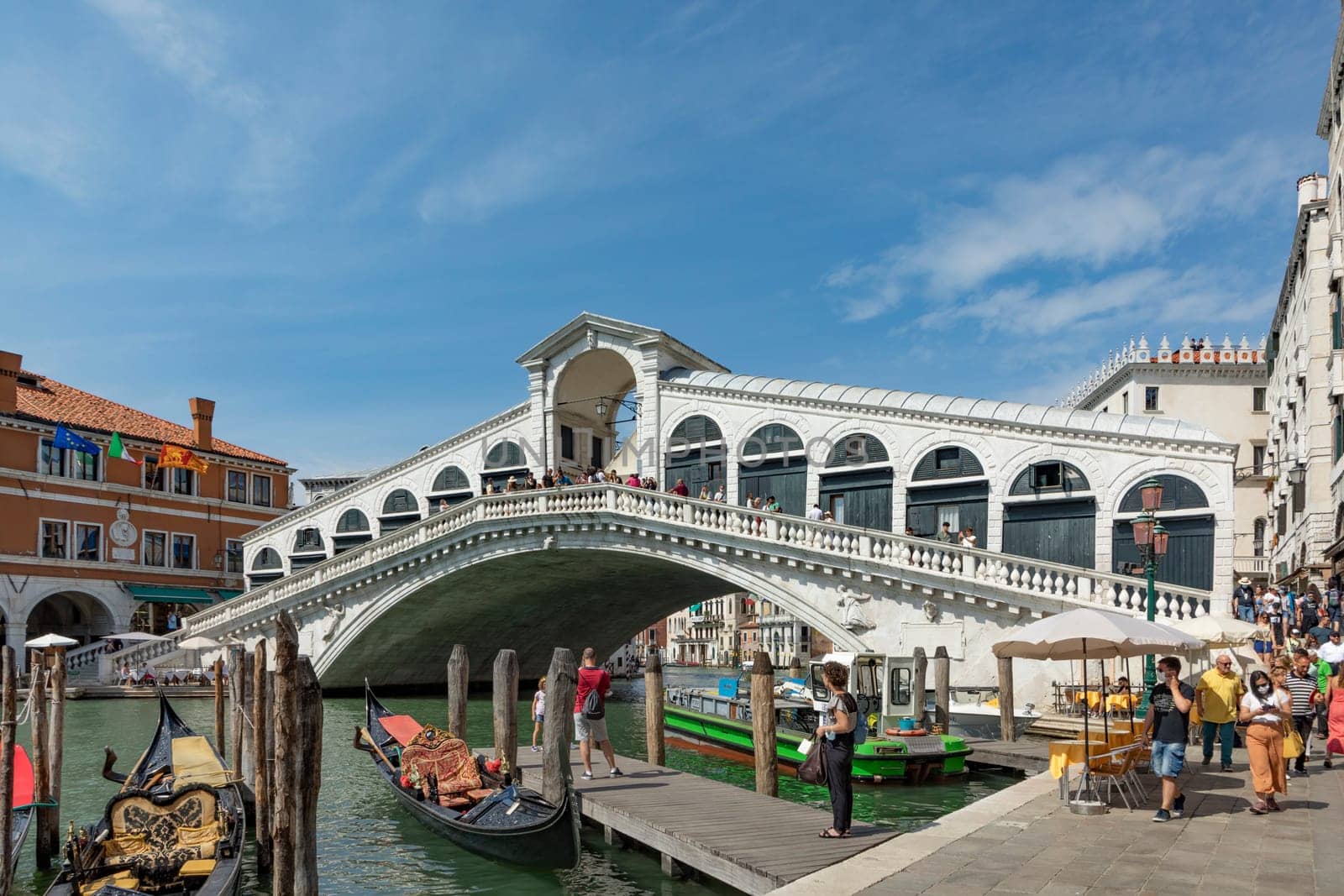 Venice, Italy - July 3, 2021: view to Rialto bridge at grand canal in Venice, Italy with boats and tourists watching the canal.